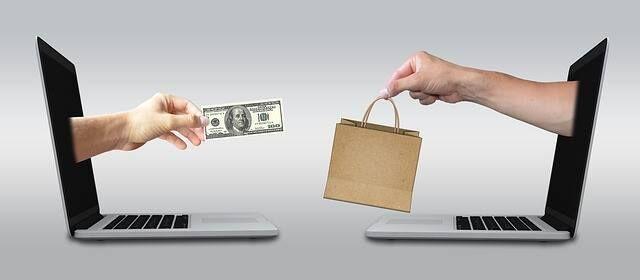 Two laptops exchanging goods for money