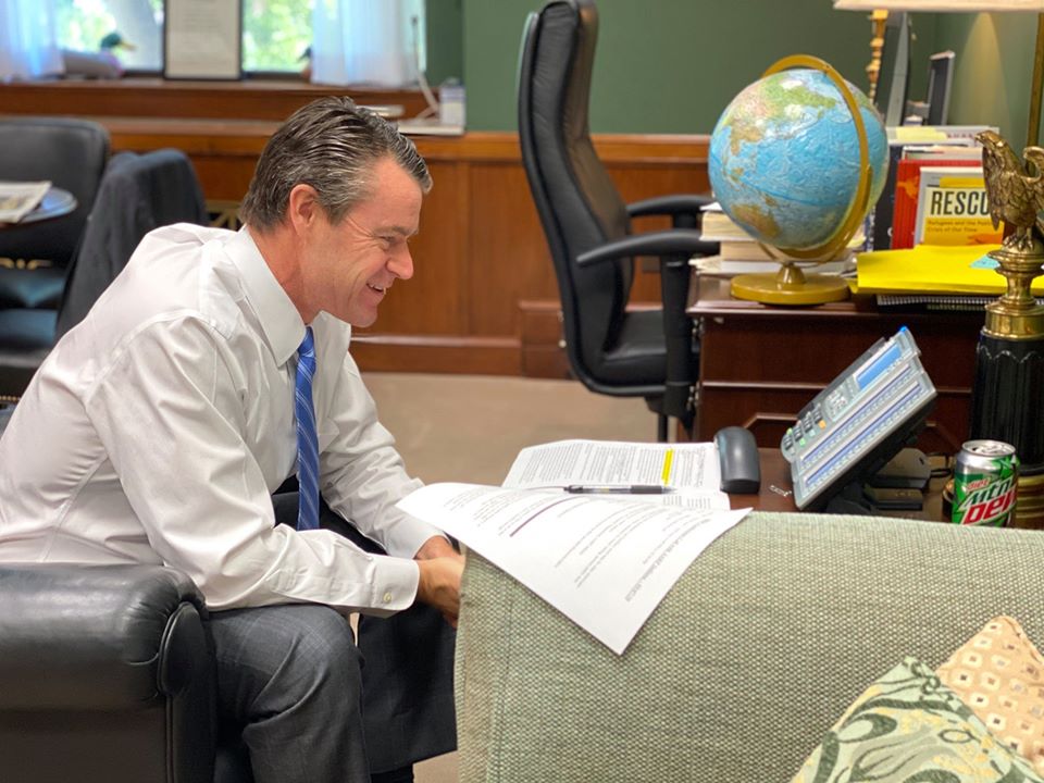 Image shows a man sitting in an office