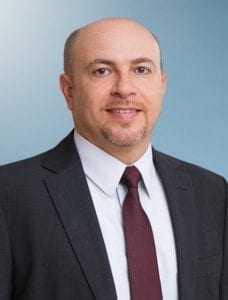 image shows a man in coat and tie