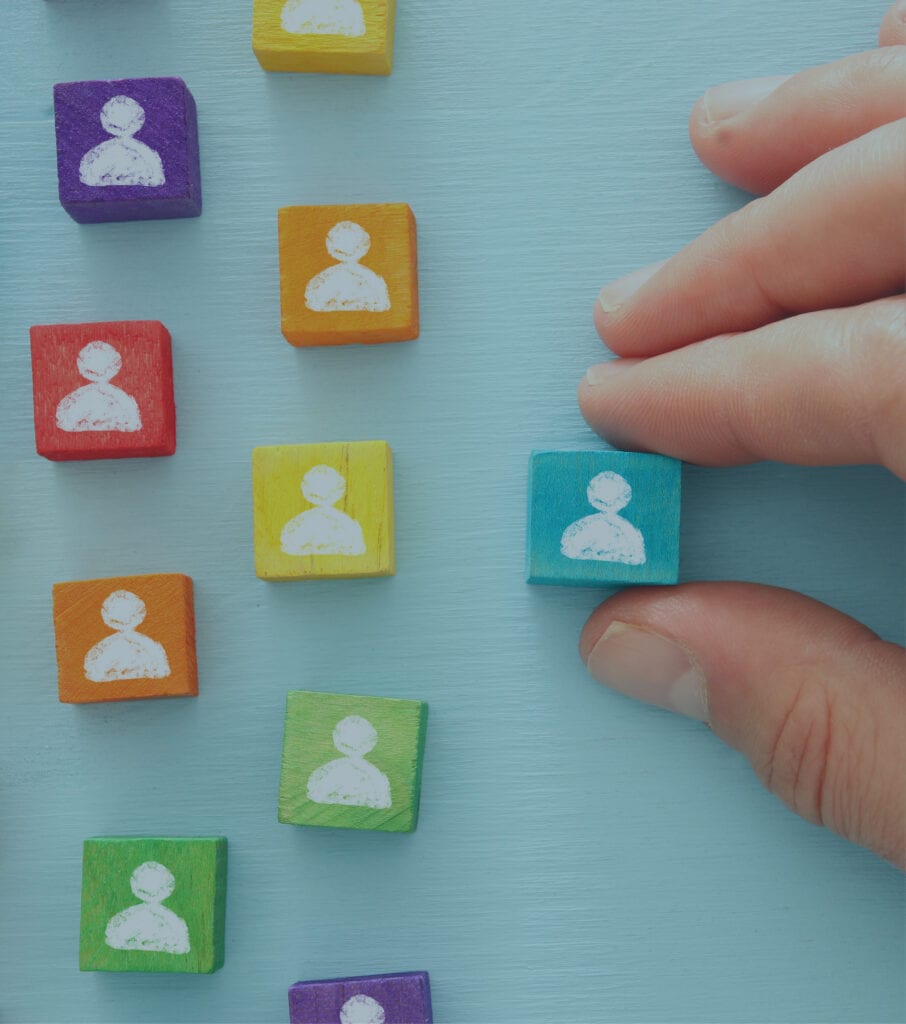 A hand placing different colored squares with head graphics on each one