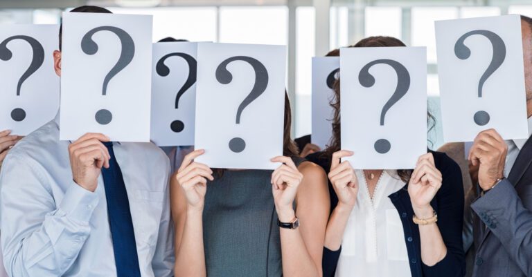 People holding up signs with question marks in front of their faces.