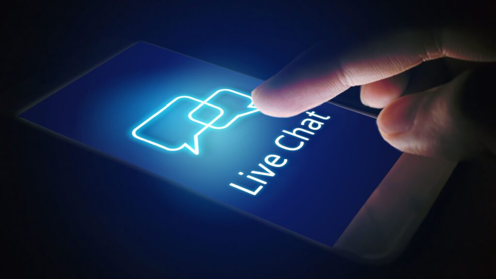 Person holding cell with phone screen showing live chat Chat